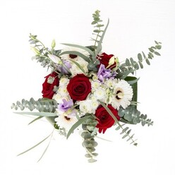 With every stem placed in this Blackheath-inspired bouquet, there's an intention to capture the area's serene, welcoming character. Creamy white gerberas, their petals extending confidently around rich brown centres, establish a sense of stability and calmness. Nestled among them, the bold red roses symbolise deep affection, each bloom spiralling open with a richness reminiscent of classic English romance. Wisps of lilac lisianthus offer a subtle, modern twist, bringing a cool, contemporary lift to the display-much like a gentle breeze tracing the paths of Blackheath Common. Sprays of eucalyptus, round-leafed and silvery, introduce texture and a fresh herbal note that lingers unobtrusively in the air, while fluffy white fillers provide a background softness, suggestive of morning clouds or soft carpeting on the heath. Dark green, structured foliage envelops the bouquet, giving it both frame and definition. Through the vase's clear glass, the healthy stems are on display, bathed in crystalline water. This arrangement is designed for all of life's gentle celebrations and meaningful milestones, offering an authentic taste of Blackheath's beauty with every petal and leaf.